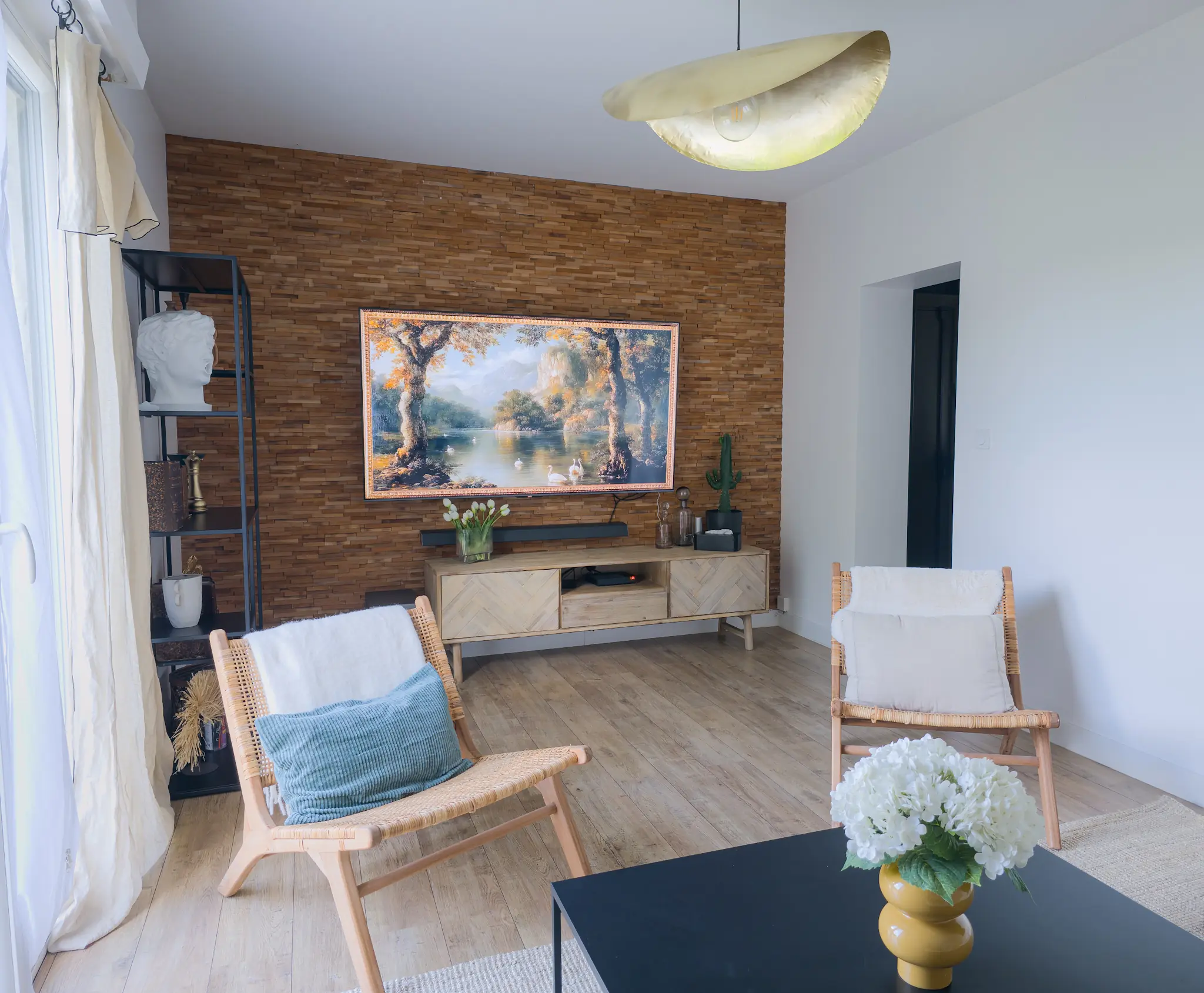 Salon du Belvédère avec fauteuils et téléviseur sur un mur habillé de bois