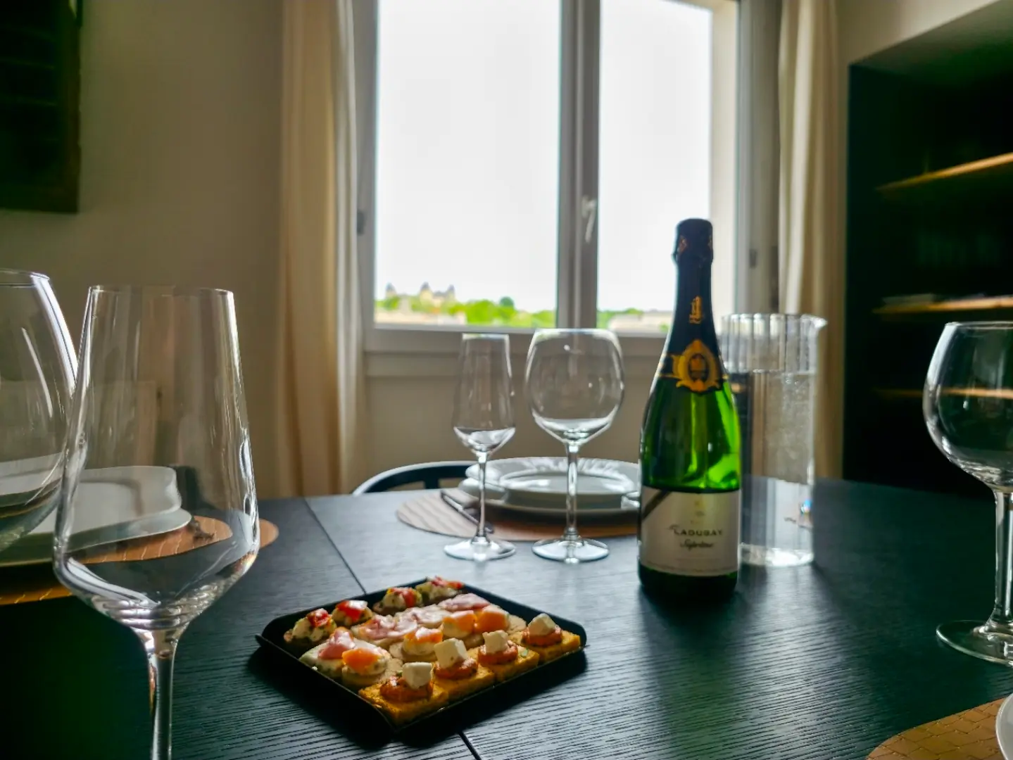 Table du Belvédère dressée pour un apéritif devant la fenêtre