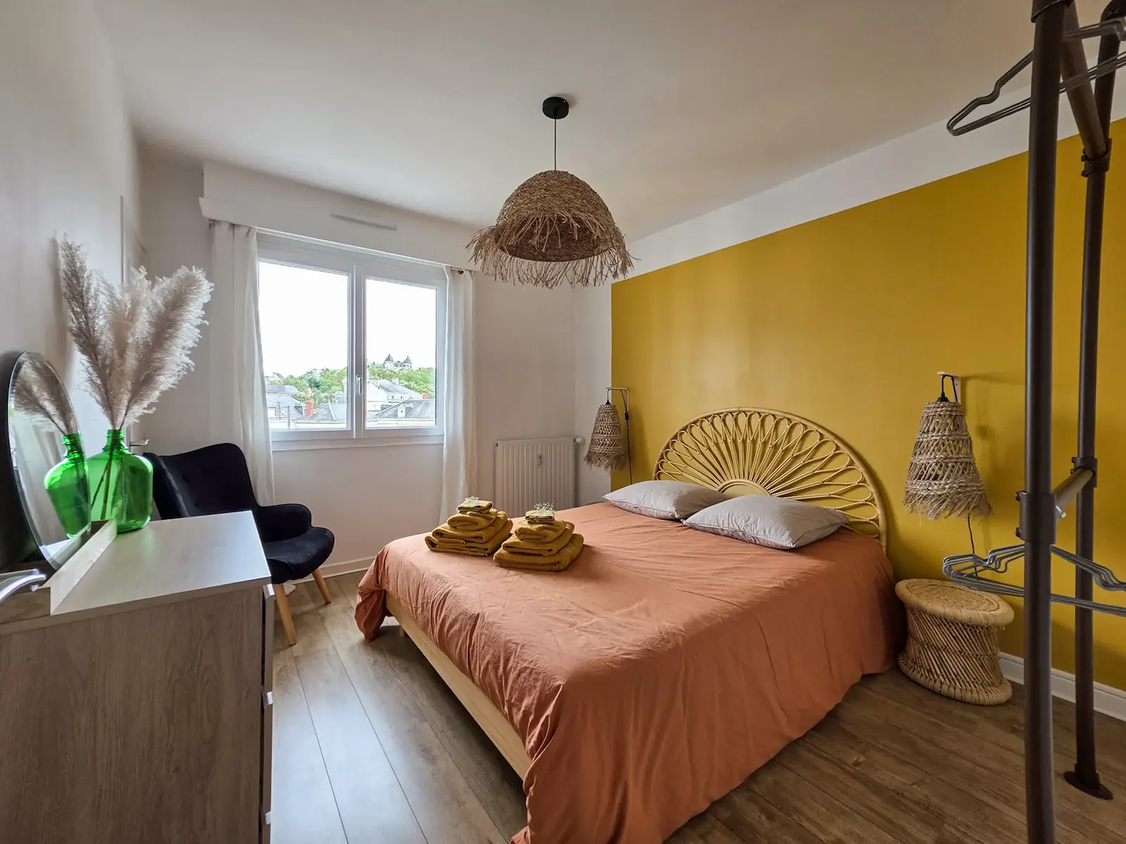 Chambre du Belvédère avec mur ocre et tête de lit en rotin
