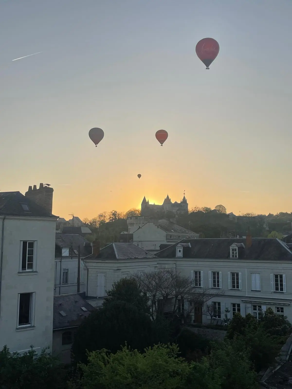 Château de Saumur et montgolfières dans un ciel doré, vus depuis Le Belvédère